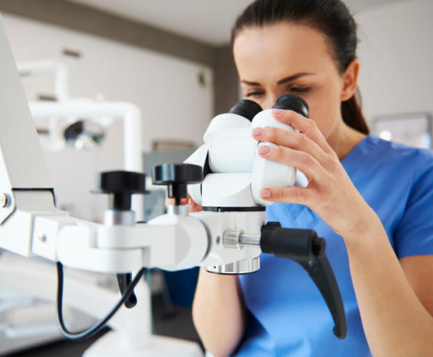 Profesional de la salud visual utilizando microscopio especializado para diagnóstico ocular.